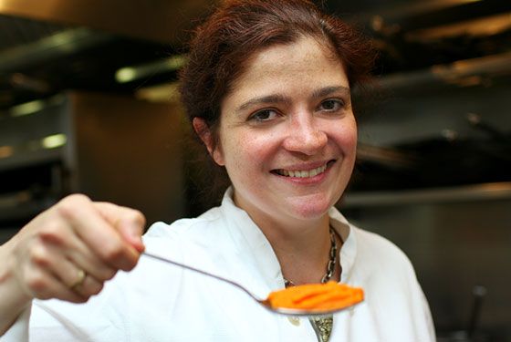 image of Chef Alex Guarnaschelli, a dark-haired middle-aged white woman, who is holding up what looks like pureed sweet potatoes