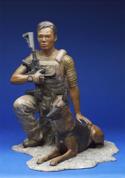 image of a bronze statue of a young Laotian-American soldier, holding a gun; beside him, in bronze form, lies his Belgian Malinois dog