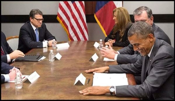 image of Obama and Perry sitting at opposite ends of a conference table, with a bunch of other people; Perry is scowling and Obama is laughing