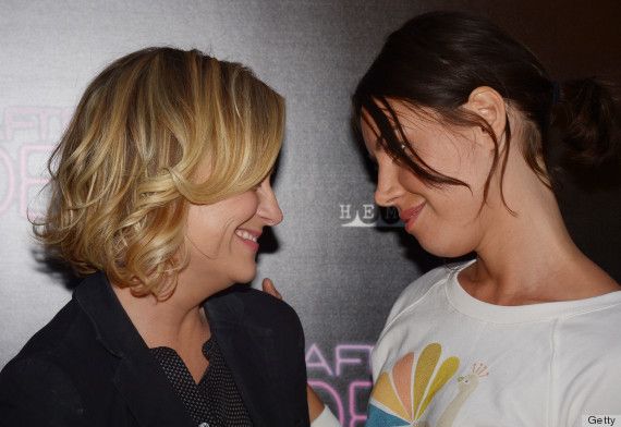 image of actresses Amy Poehler, a white middle-aged woman with blond hair, and Aubrey Plaza, a latina woman with dark hair, looking at each other fondly