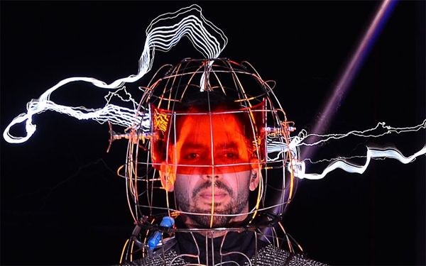 image of David Blaine with his head in some sort of metal cage being hit by lightning