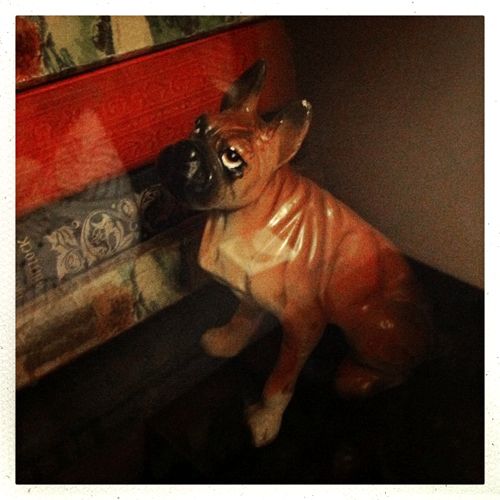 image of a boxer (dog) figurine sitting next to some old books