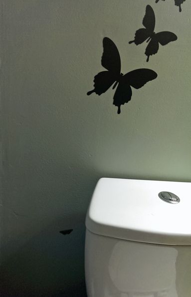 image of the same wall, with something stuck on the wall just below the butterfly decals