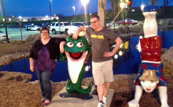 image of Deeky and me standing next to a giant cartoonish statue of a fish with a human man on a line