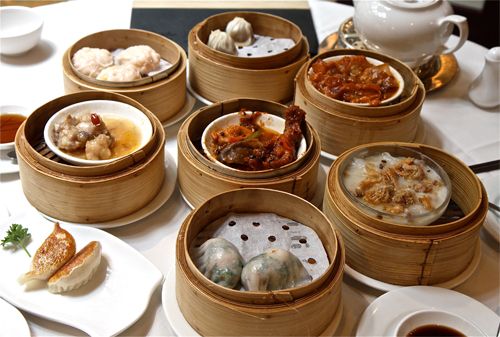 image of dim sum, i.e. Cantonese food prepared as small bite-sized or individual portions of food, on a nicely dressed table