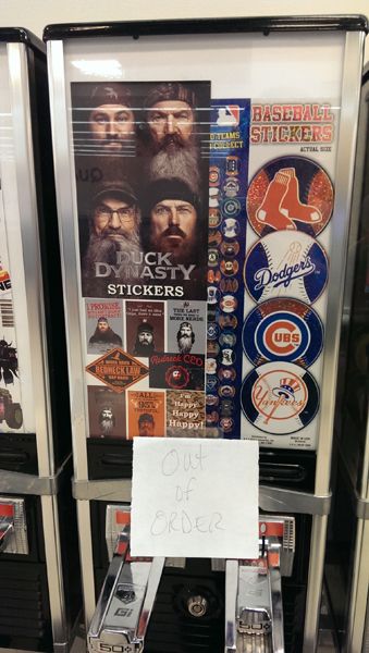 image of a sticker dispensing machine for children full of Duck Dynasty stickers, with a handwritten 'Out of Order' sign stuck to it
