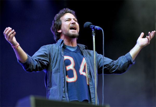 image of Pearl Jam lead singer Eddie Vedder singing at a concert