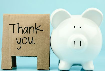 image of a piggy bank with a sign reading 'thank you' next to it