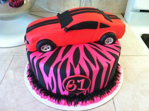 image of a cake that is a red mustang car sitting on top of a pink tiger striped layer of cake