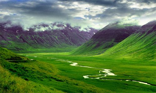 image of clouds over a lush green valley in Iceland