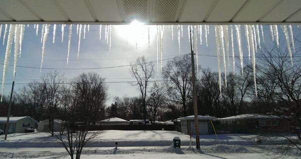 the view from my front porch of icicles hanging off our roof, above the snowy tundra that used to be my front yard