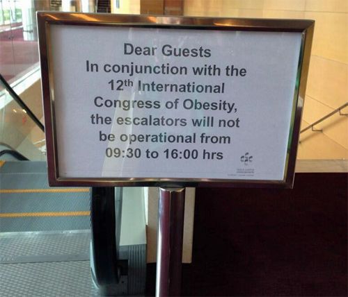 image of a sign reading: 'Dear Guests In conjunction with the 12th International Congress of Obesity the escalators will not be operational from 09:30 to 16:00 hrs.'