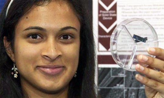 image of Eesha Khare, a young woman of color, holding up her invention