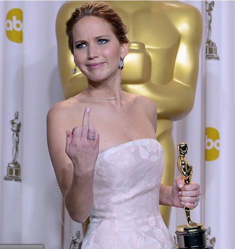 image of actress Jennifer Lawrence flipping off a reporter at the Oscars, while holding her Academy Award