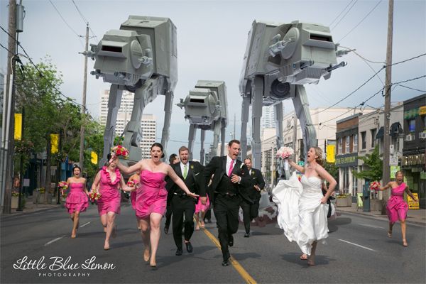 image of a bridal party including bridge, groom, groomsmen, and bridesmaids in full wedding regalia, running down the street hollering as they are 'chased' by AT-ATs from Star Wars