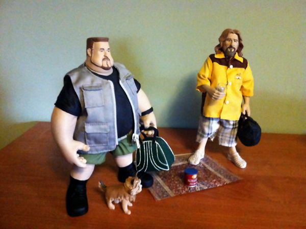 image of a set of figurines from The Big Lebowski, including The Dude, Walter, Walter's ex-wife's dog, a coffee can with Donnie's ashes, two bowling ball bags, and a rug that really ties the room together