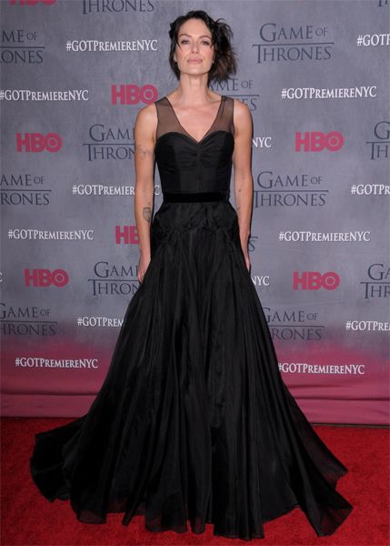 image of actress Lena Headey, a tall, thin, white, brunette woman, wearing a flowing black dress and looking defiant