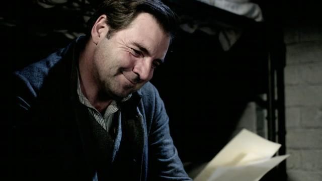 image of Bates (Brendan Coyle) reading a letter in jail and smiling