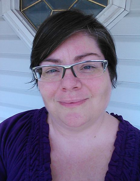 image of me, a fat middle-aged white woman with short, greying brown hair and glasses, on my front porch