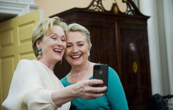 image of Meryl Streep and Hillary Clinton grinning while taking a self-photo with an iPhone