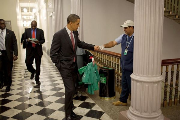 President Obama fist-bumping a member of the White House cleaning crew as he walks by