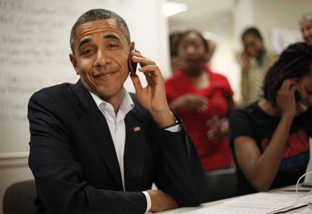 image of President Obama at a call center, holding a mobile phone to his ear and makes a whoopsface