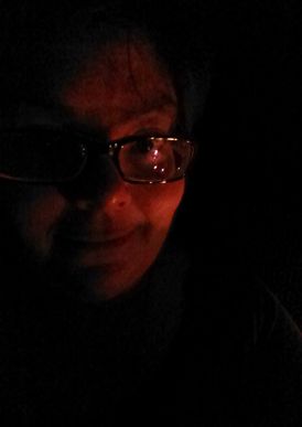 image of my face lit my candlelit in an otherwise dark room