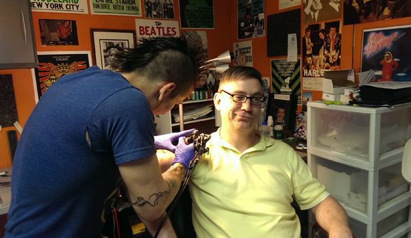 image of Deeky getting tattooed on his upper right arm by Lui