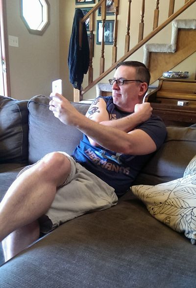image of Deeky taking a selfie of his new tattoo while sitting on my couch