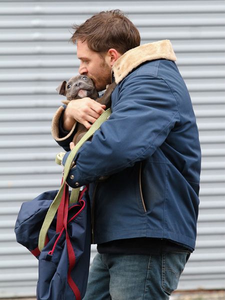 image of Hardy kissing the puppy while cradling it in his arms