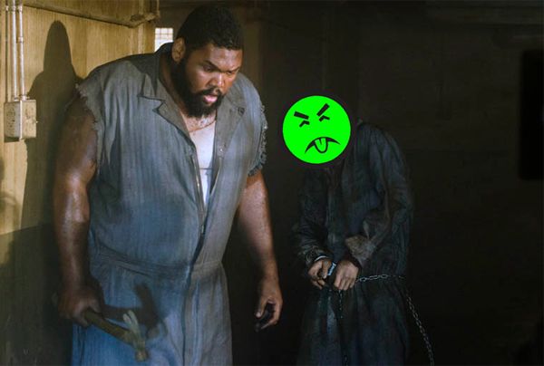 screen cap of a tall black male prisoner called Big Tiny being stalked by a zombie in the latest episode of The Walking Dead; the zombie's face has been replaced by a Mr. Yuck sticker