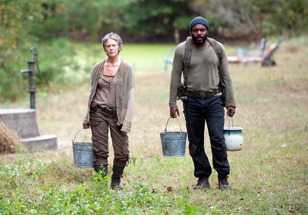 image of Carol and Tyreese walking through a field carrying buckets of water and looking pretty demoralized