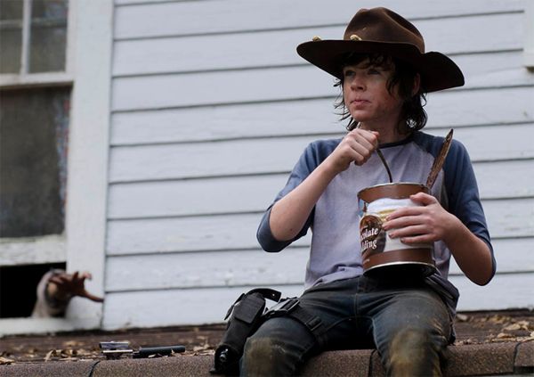 image of Carl the Hat sitting on a roof eating out of a giant canister of chocolate pudding; a zombie hand reaches out of a window behind him