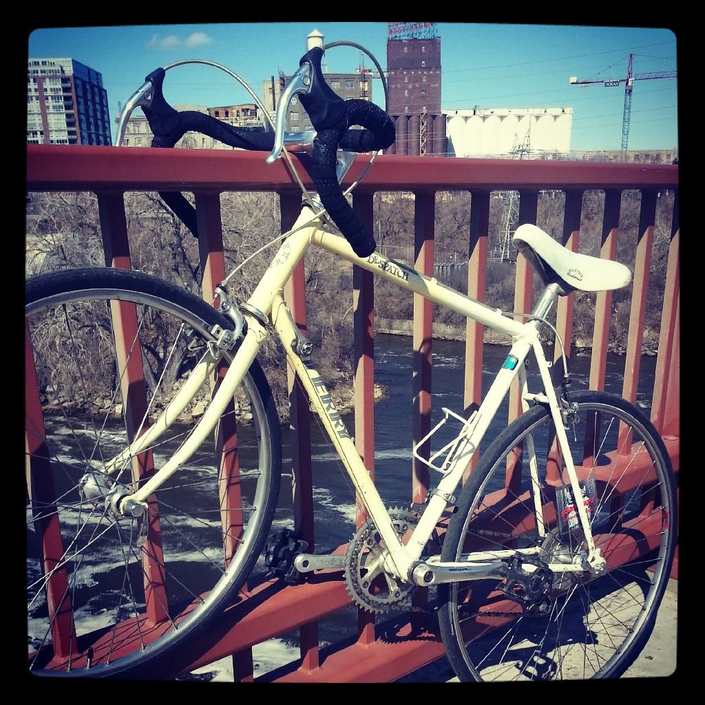 bike next to a railing on a bridge over the river, overlooking a city