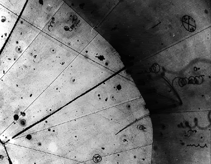 The world's first neutrino observation in a hydrogen bubble chamber was found Nov. 13, 1970, on this historical photograph from the Zero Gradient Synchrotron's 12-foot bubble chamber. The invisible neutrino strikes a proton where three particle tracks originate (right). The neutrino turns into a mu-meson, the long center track. The short track is the proton. The third track is a pi-meson created by the collision. (image and caption taken from Argonne National Laboratory) The world's first neutrino observation in a hydrogen bubble chamber was found Nov. 13, 1970, on this historical photograph from the Zero Gradient Synchrotron's 12-foot bubble chamber. The invisible neutrino strikes a proton where three particle tracks originate (right). The neutrino turns into a mu-meson, the long center track. The short track is the proton. The third track is a pi-meson created by the collision. (image and caption taken from Argonne National Laboratory)