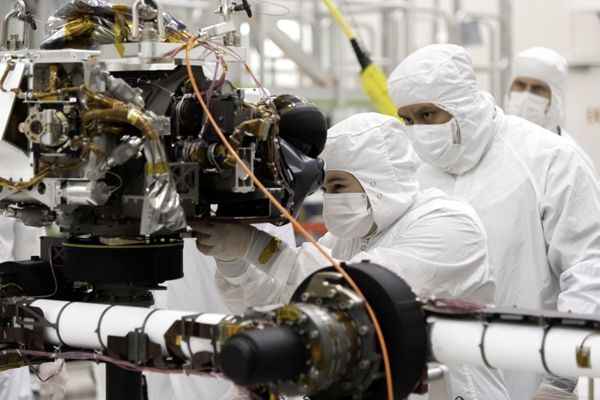 Engineers install the sensor turret to the Mars 2020 rover's robotic arm at NASA's Jet Propulsion Laboratory near Pasadena, California...on July 11, 2019.