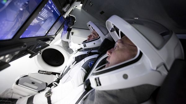 NASA astronauts Bob Behnken and Doug Hurley (foreground) train for the upcoming Demo-2 mission inside SpaceX's flight simulator.