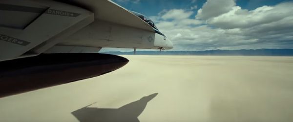 The F/A-18 Hornet piloted by Maverick flies across a dry lake bed in the desert in TOP GUN: MAVERICK.