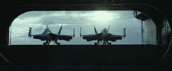 Two F/A-18 Hornets are brought up to an aircraft carrier's flight deck in TOP GUN: MAVERICK.