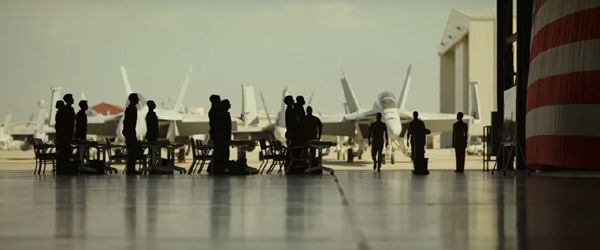 Aviators stand at attention at a U.S. naval base in TOP GUN: MAVERICK.