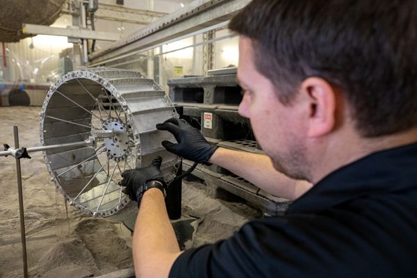 A robotics engineer at NASA's Kennedy Space Center in Florida prepares to conduct a dust test on a replica of the VIPER lunar rover's wheel...on March 17, 2020.