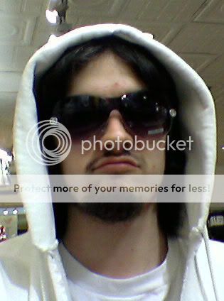 A male with a white hoodie, longer hair and sunglasses one